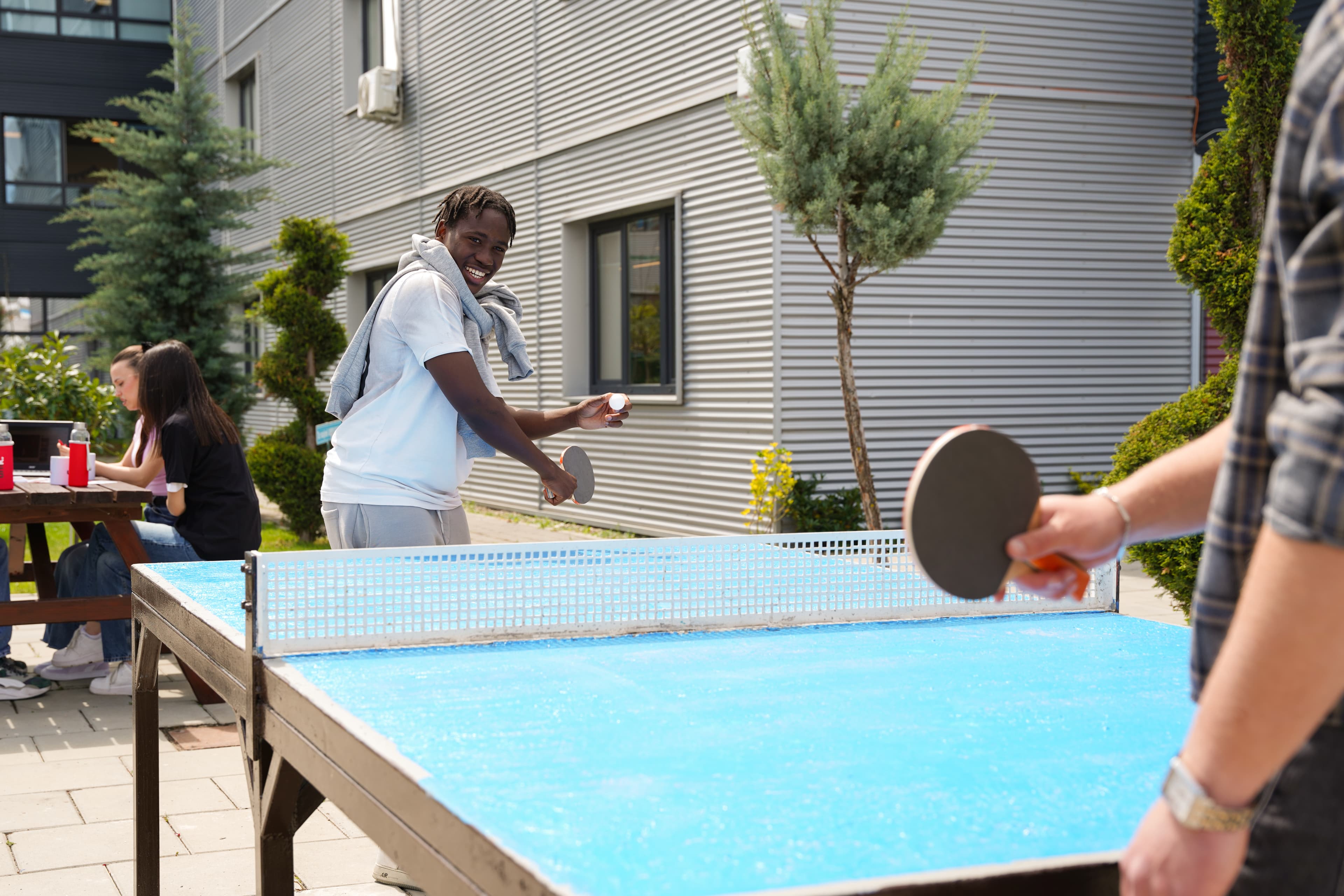 Studentë duke luajtur ping-pong në një hapësirë të përbashkët të kampusit UNI